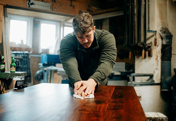 Mann wischt Holztisch