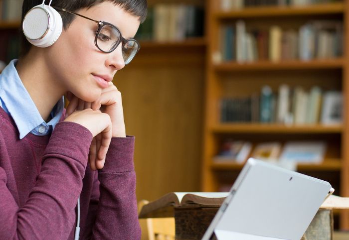Frau arbeitet am Laptop mit Kopfhörern